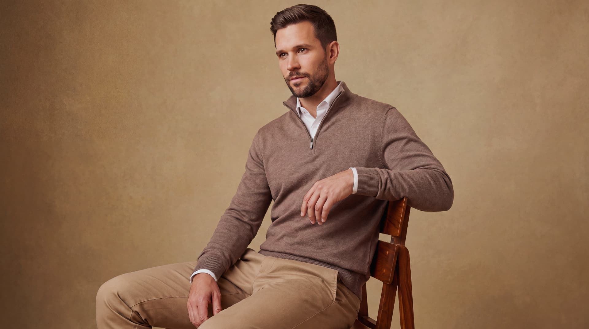 Man wearing a brown quarter-zip sweater over a white dress shirt